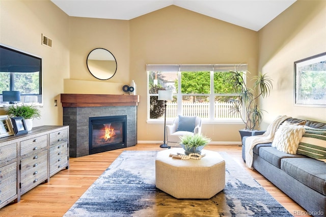 9168 W 50th Ln Unit 1, Arvada, CO 80002 - living room with wood finished floors, a tiled fireplace, and high vaulted ceiling