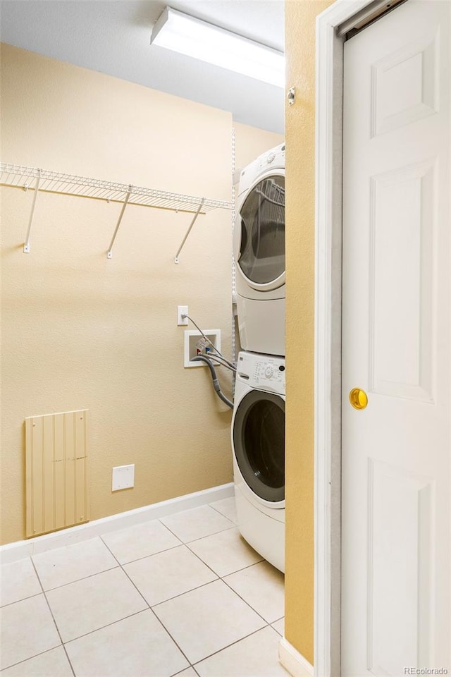 9168 W 50th Ln Unit 1, Arvada, CO 80002 - laundry room featuring estacked washer and dryer, light tile patterned floors, and radiator heating unit