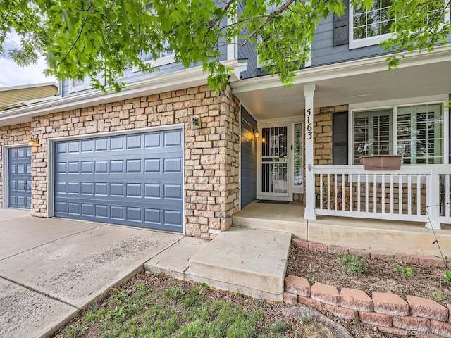 5163 Apache Creek Rd, Castle Rock, CO 80109 - property entrance featuring a porch, a garage, driveway, and stone siding