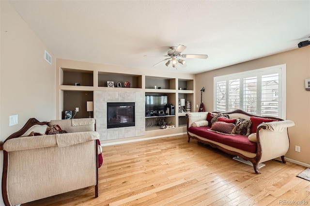 5163 Apache Creek Rd, Castle Rock, CO 80109 - living room with wood finished floors, ceiling fan, a fireplace, built in features, and baseboards