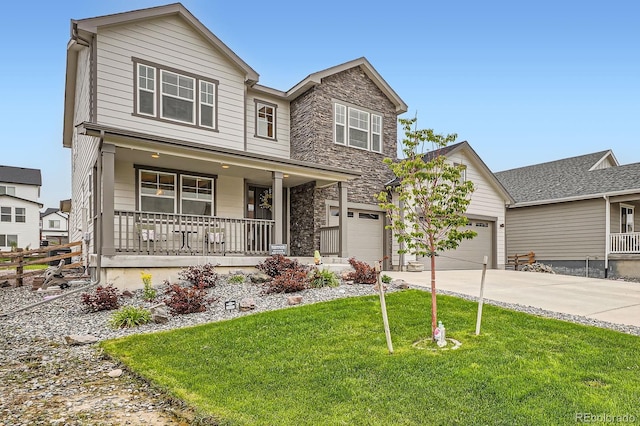 1403 Hart Ln, Elizabeth, CO 80107 - view of front of property with covered porch, driveway, a front lawn, stone siding, and a garage