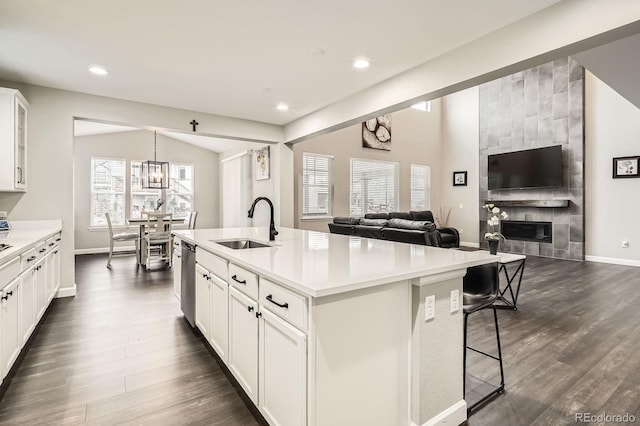 1403 Hart Ln, Elizabeth, CO 80107 - kitchen featuring a sink, dishwasher, open floor plan, a tiled fireplace, and dark wood-style flooring