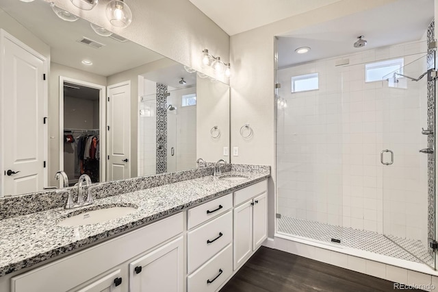 1403 Hart Ln, Elizabeth, CO 80107 - bathroom with a shower stall, double vanity, a walk in closet, and wood finished floors