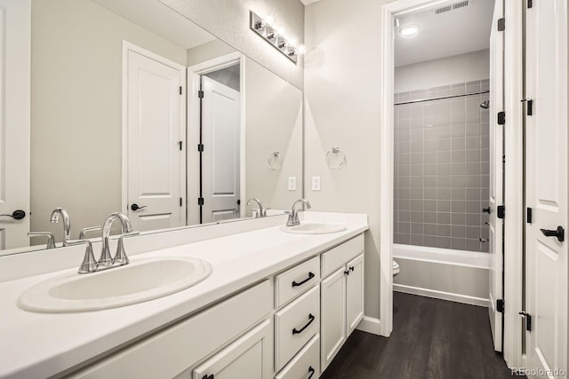 1403 Hart Ln, Elizabeth, CO 80107 - full bathroom featuring double vanity, toilet, wood finished floors, and bathtub / shower combination