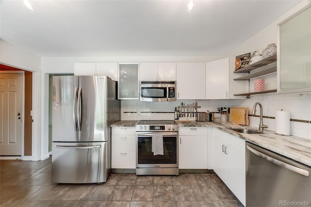 1565 Sagrimore Cir, Lafayette, CO 80026 - kitchen featuring appliances with stainless steel finishes, open shelves, tasteful backsplash, and white cabinetry