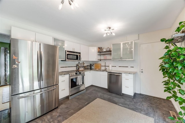 1565 Sagrimore Cir, Lafayette, CO 80026 - kitchen with appliances with stainless steel finishes, open shelves, white cabinets, glass insert cabinets, and decorative backsplash