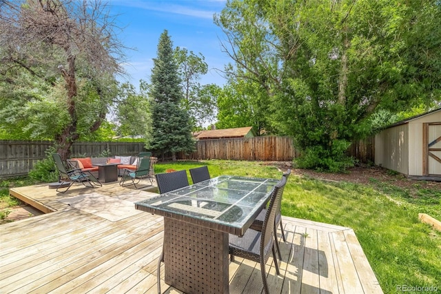 1565 Sagrimore Cir, Lafayette, CO 80026 - wooden terrace with a fenced backyard, outdoor dining area, a storage unit, and a fire pit