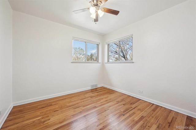 spare room featuring baseboards, visible vents, light wood-style floors, and ceiling fan