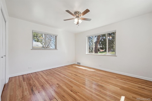 empty room with wood finished floors, baseboards, and ceiling fan