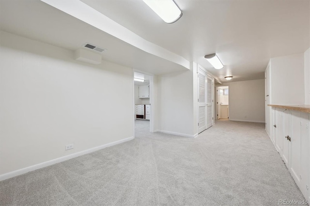 finished basement with visible vents, baseboards, and light carpet