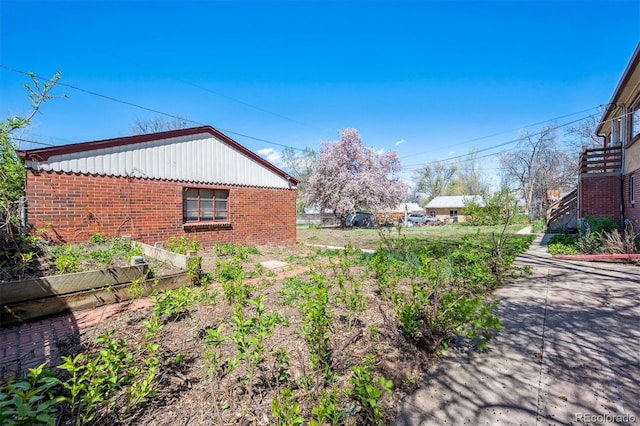view of home's exterior with a garden and brick siding