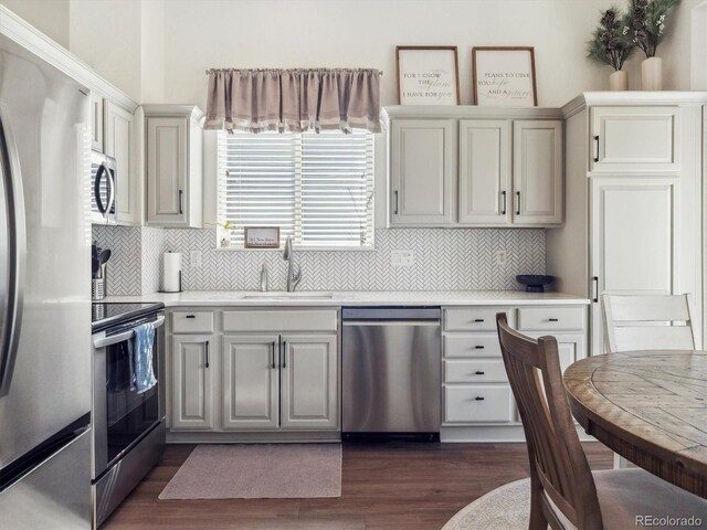 kitchen featuring appliances with stainless steel finishes, a sink, light countertops, and decorative backsplash