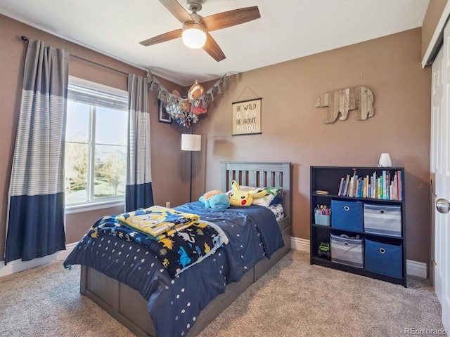 carpeted bedroom featuring baseboards and a ceiling fan