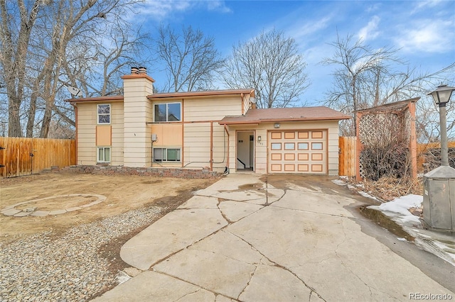 1262 Lanyon Ln, Longmont, CO 80503 - view of front of home with an attached garage, a chimney, and concrete driveway