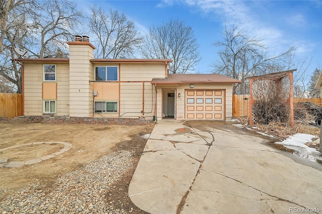 1262 Lanyon Ln, Longmont, CO 80503 - view of front of home with an attached garage, concrete driveway, and a chimney