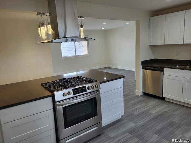 1262 Lanyon Ln, Longmont, CO 80503 - kitchen featuring stainless steel appliances, island range hood, dark countertops, white cabinets, and recessed lighting