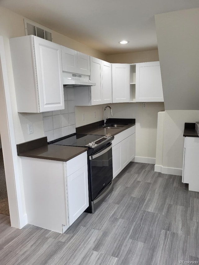 1262 Lanyon Ln, Longmont, CO 80503 - kitchen with electric range, under cabinet range hood, white cabinets, open shelves, and recessed lighting