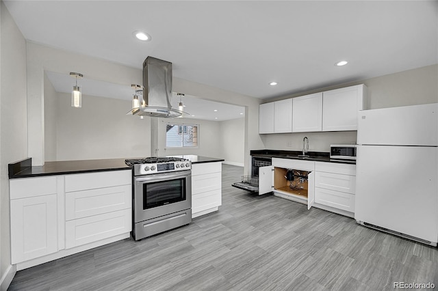 1262 Lanyon Ln, Longmont, CO 80503 - kitchen with freestanding refrigerator, gas range, island range hood, dark countertops, and white cabinets