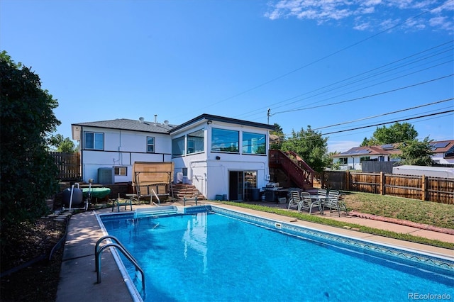 2141 W Gill Pl, Denver, CO 80223 - rear view of property with stairs, a fenced backyard, stucco siding, a patio area, and a sunroom