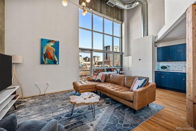 living room featuring a high ceiling and light hardwood / wood-style flooring