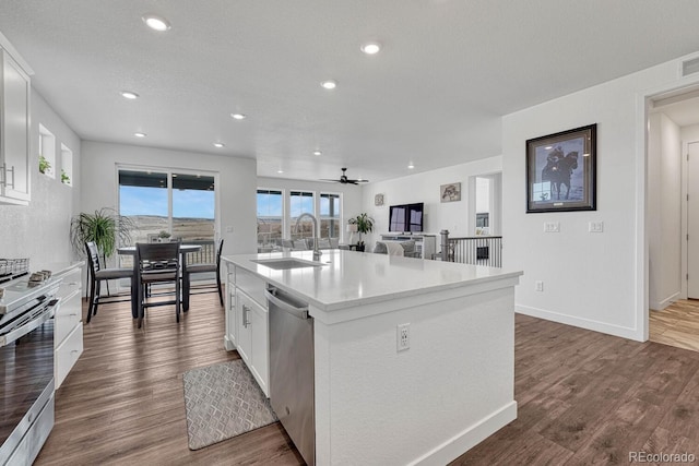 kitchen with sink, a center island with sink, appliances with stainless steel finishes, dark hardwood / wood-style flooring, and white cabinets