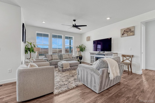 living room with wood-type flooring and ceiling fan