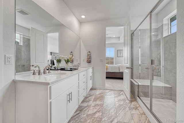 bathroom featuring a shower with door, vanity, and plenty of natural light