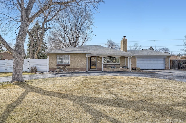 ranch-style home with a front yard, fence, a garage, and a chimney