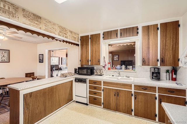 kitchen featuring a sink, white dishwasher, brown cabinetry, and black microwave