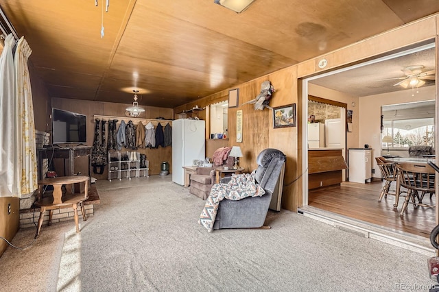 living area with wooden walls and a ceiling fan