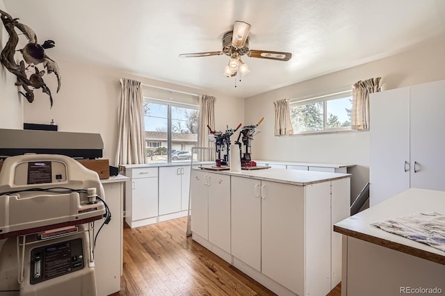 kitchen featuring white cabinetry, plenty of natural light, light wood-style floors, and a ceiling fan