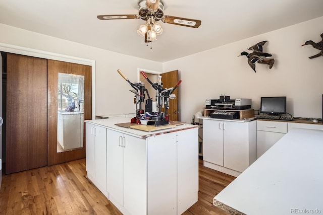 kitchen featuring light wood-type flooring, light countertops, a ceiling fan, and white cabinetry