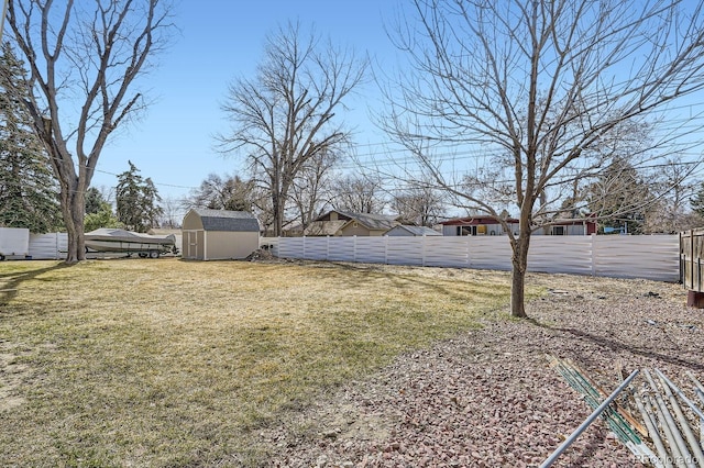 view of yard featuring an outdoor structure, a fenced backyard, and a shed