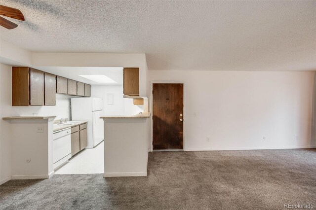 14192 E Colorado Dr Unit 102, Aurora, CO 80012 - kitchen with light countertops, a textured ceiling, light carpet, and white appliances
