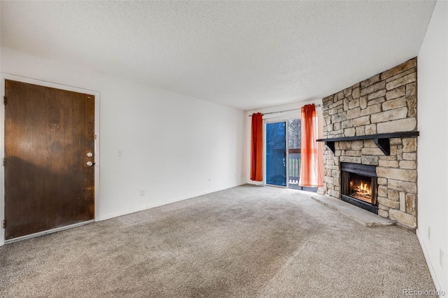 unfurnished living room featuring carpet flooring, a textured ceiling, baseboards, and a fireplace