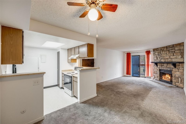 14192 E Colorado Dr Unit 102, Aurora, CO 80012 - kitchen with light carpet, white appliances, a stone fireplace, a textured ceiling, and under cabinet range hood