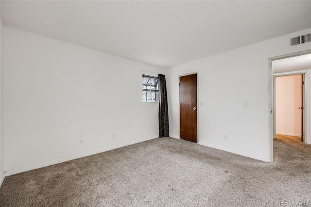 unfurnished bedroom featuring carpet floors, baseboards, and visible vents