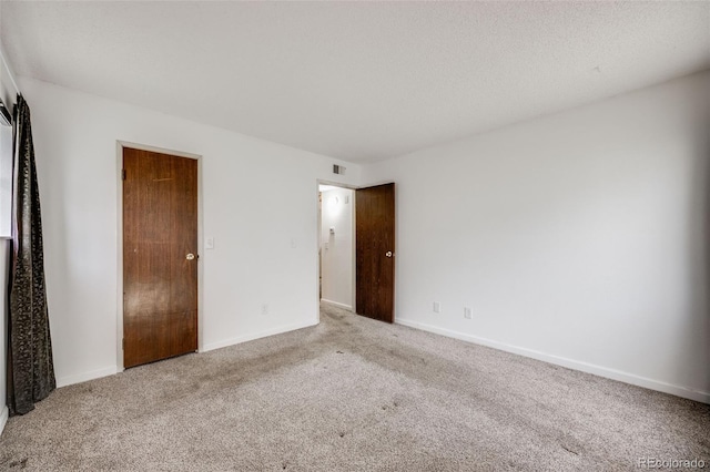 carpeted empty room with baseboards and visible vents