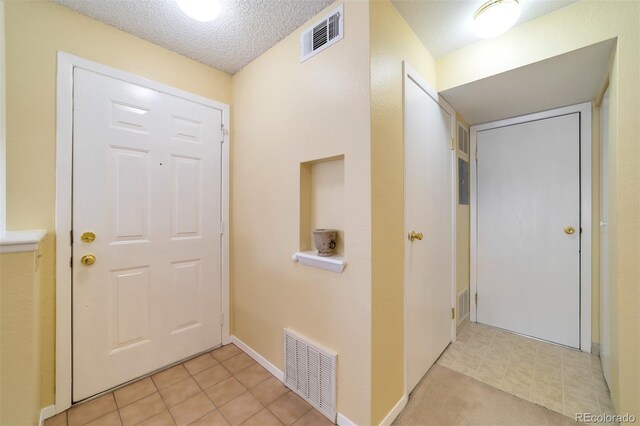 6001 S Yosemite St Unit B203, Greenwood Village, CO 80111 - entrance foyer featuring light tile patterned flooring and a textured ceiling