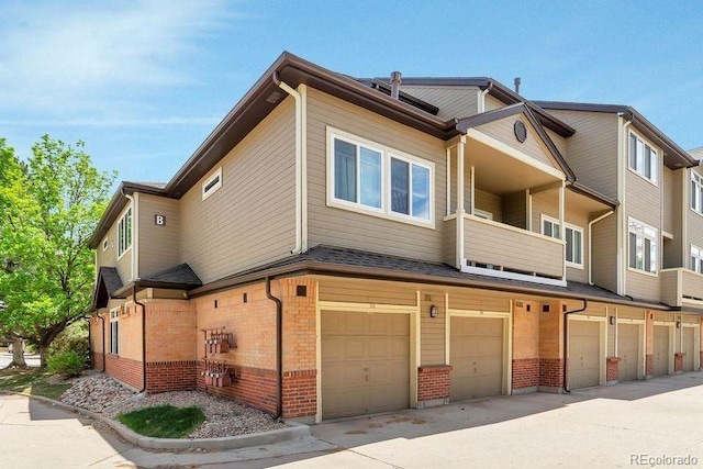 6001 S Yosemite St Unit B203, Greenwood Village, CO 80111 - view of front of house featuring brick siding, a garage, and a balcony
