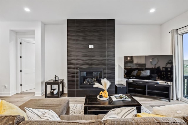 living room with light hardwood / wood-style flooring and a tile fireplace