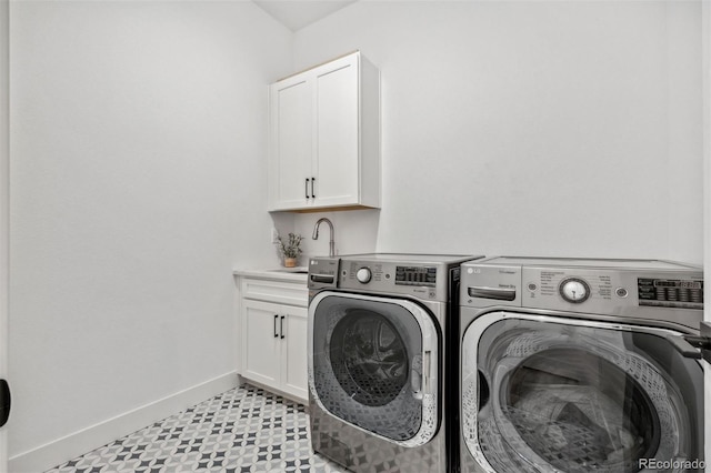 washroom featuring sink, independent washer and dryer, and cabinets