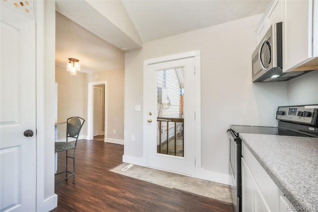 614 W Kiowa St, Colorado Springs, CO 80905 - kitchen with stainless steel appliances, dark wood finished floors, white cabinetry, vaulted ceiling, and baseboards