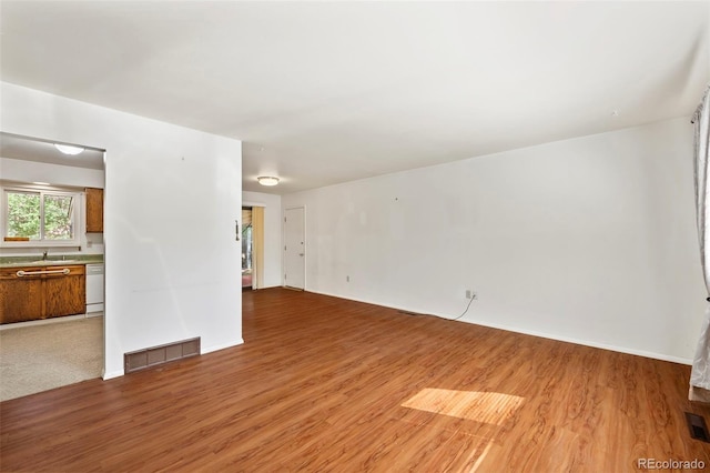 unfurnished room with light wood-type flooring and sink