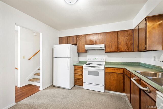 kitchen with light hardwood / wood-style floors, white appliances, and sink