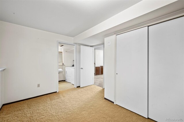 unfurnished bedroom with light carpet, ensuite bathroom, a closet, and washer and clothes dryer