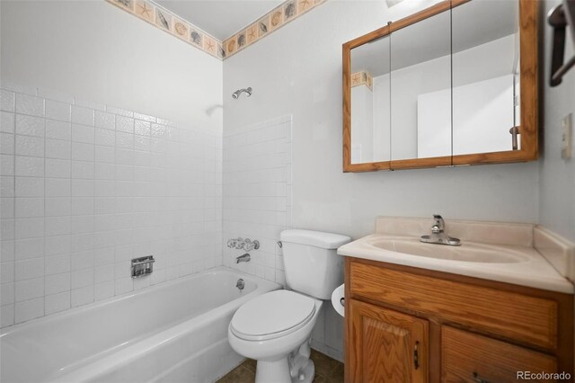 full bathroom featuring tiled shower / bath, vanity, and toilet