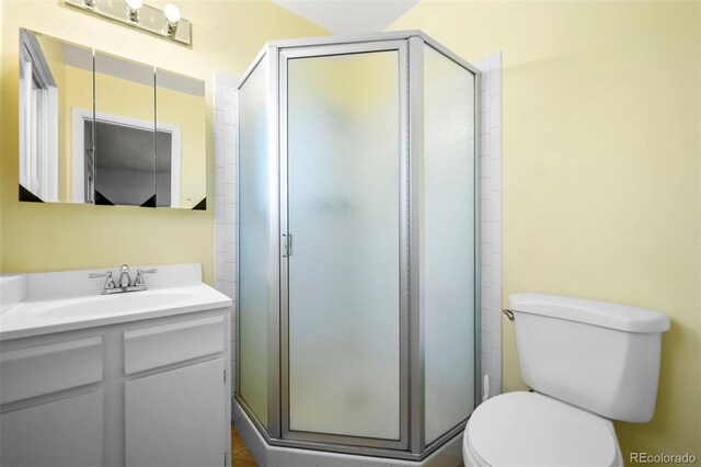 bathroom with vanity, toilet, and an enclosed shower