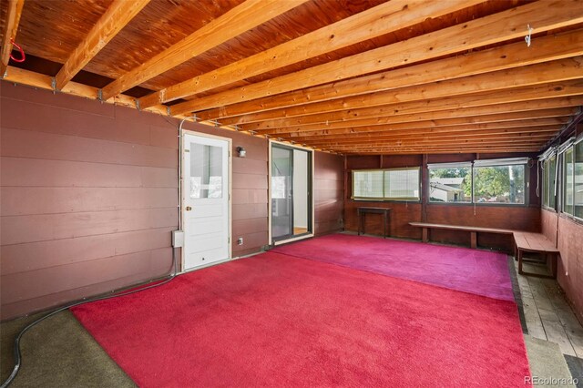 unfurnished sunroom with beamed ceiling