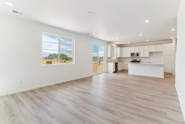 449 S Salida St, Aurora, CO 80017 - unfurnished living room with light wood-style flooring, recessed lighting, and baseboards
